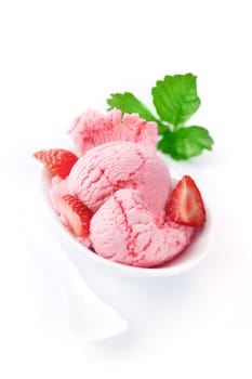 Strawberry icecream garnished with fresh ripe red strawberries served in a white oval dish