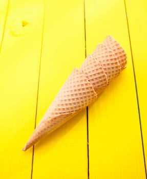 Four ice cream cones on yellow table