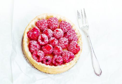High angle Fruity Tart with delicious raspberries and powdered sugar