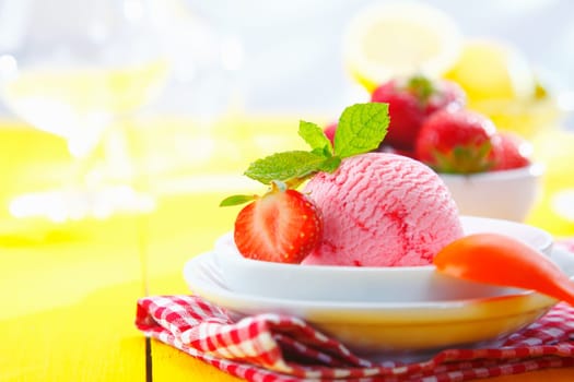 Tropical strawberry icecream served with fresh ripe strawberries in a tabletop setting on a summer vacation