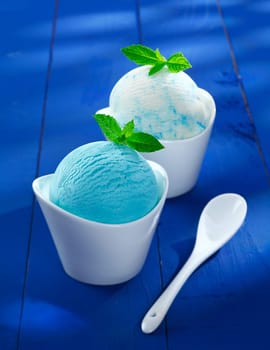 Servings of refreshing blue Italian icecream in decorative boat shaped individual dishes garnished with mint
