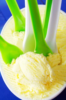 Many Ice Cream Spoons in vanilla icecream. Summer party with frozen ice-cream.