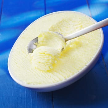 Vanilla Icecream Dessert in a bowl on a blue wooden background. For ice cream concepts look at my portfolio