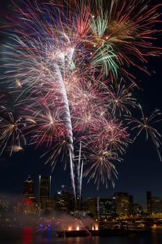 Multi-Color Fireworks Display Over Portland Oregon Skyline Along Willamette River Waterfront at Night