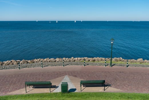 two empty benches in front of a large lake in the Netherlands
