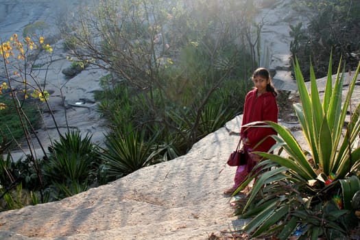 Girl in red sweater strolling in the garden