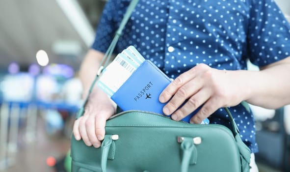Man putting passport with plane tickets in laptop bag closeup. Flight by plane concept