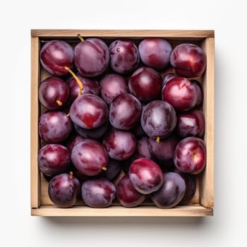 Group of plums inside a wooden rustic container isolated on white background. top view.