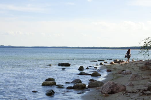 Girl on the beach with big stones