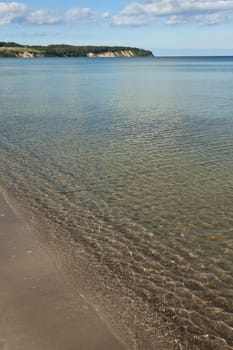 Small waves break with reflections on the beach