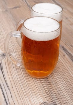 Two Glasses of Beer on Old Wooden Table