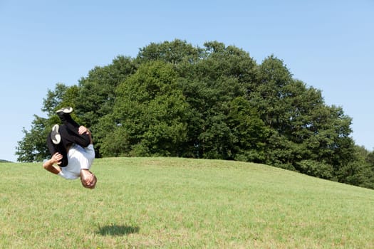 Somersault in nature,young man doing sports training