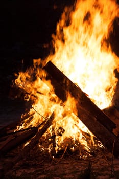Large campfire in which boards burn