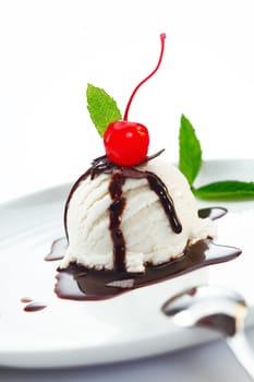 Delicious ice cream ball topped with chocolate and fresh cherry