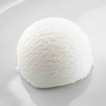 Single scoop of refreshing tangy sour lemon sorbet dessert on a white plate