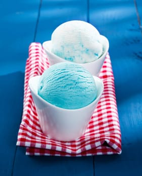 Gourmet individual servings of blue Italian icecream served in elegant boat-shaped dishes on a red and white checkered napkin