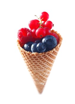 Assorted Fruit Mix in an icecream cone. Bilberries raspberries and redcurrants on a blank white background