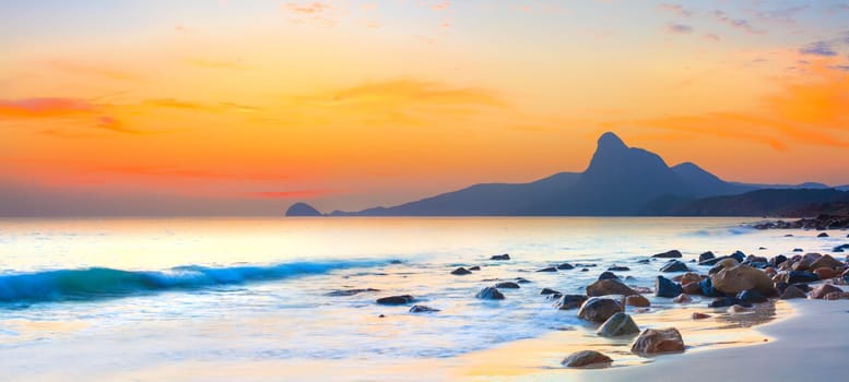 Sunset over the sea. Stone on the foreground. Panorama