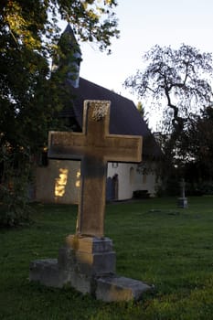 Grave cross in front of the church in Reher