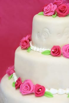 Three tier wedding cake decorated with pink marsipan roses