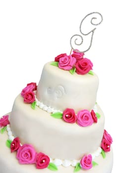 Wedding cake covered in ivory marzipan and decorated with pink roses