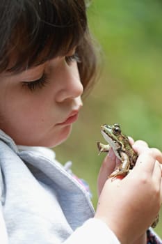 details of a frog in the hands of a girl