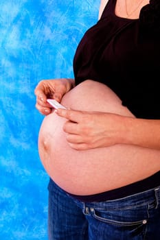 pregnant woman with pregnancy test on the blue mosaic background