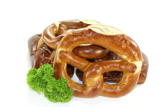 Pretzel pastries with parsley against a white background