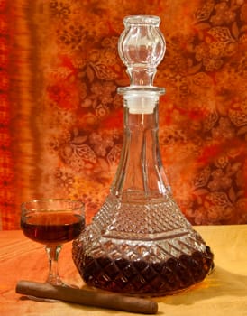 Glass and bottle of brandy with orange gradient background