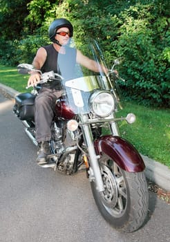 A middle-aged man is riding a motorcycle.