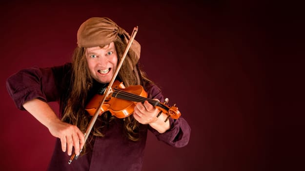 17th Century Pirate Playing Violin and Announcing Something on a banner with copy space.