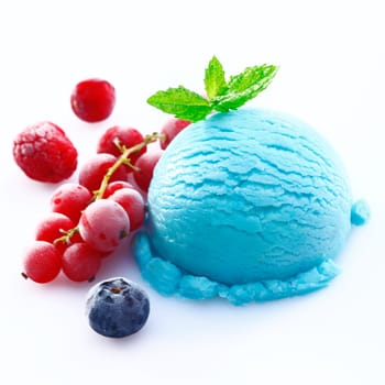 Scoop of blueberry icecream with chilled redcurrants, raspberries and a blueberry on a white background