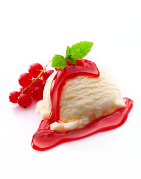 Vanilla ice-cream dessert topped with redcurrant syrup and served with fresh fruit on a white background