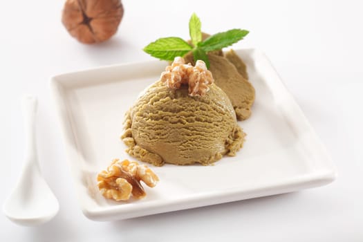Delicious ice cream decorated with fresh nuts and mint leaves