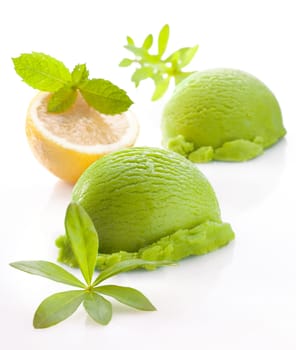 Scoops of fresh green lemon or lime icecream on a white studio background with faint reflection