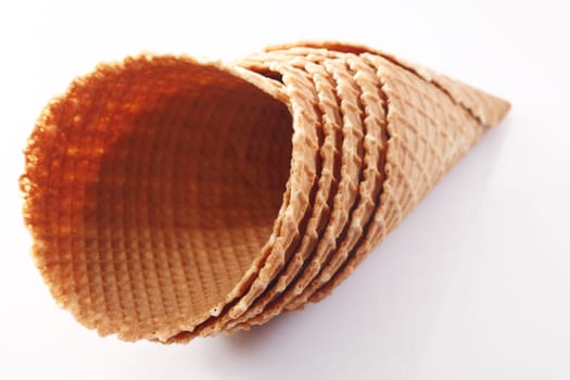 Stack of wide waffle pattern wafer ice-cream cones suitable for double scoop servings on white