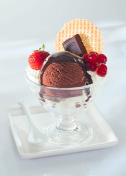 Rich mouth watering chocolate ice-cream topped with melted chocolate and served garnished with squares of slab chocolate, berries and a wafer