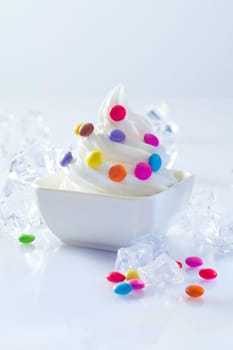 Individual serving od soft-serve icecream dessert dotted with colourful round candy ready for a childs birthday party