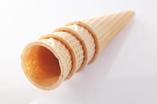 Stack of waffle pattern wafer icecream cones on white background. Visit my portfolio for more.