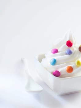 Soft-serve icecream whirl with colourful round candy ready for a childs bithday party with copyspace