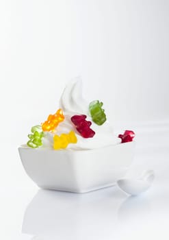 Stylish frozen yoghurt with jellybaby topping isolated on white background
