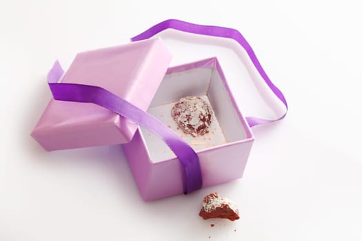 Pretty lilac-coloured gift box with a decorative matching ribbon open to display the last remaining handmade chocolate truffle