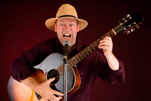 A man is playing acoustic guitar and singing.