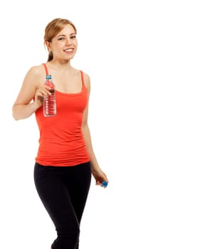 Happy young sportswoman with a bottle of water against a white background