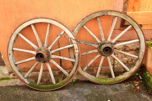 old,wooden wagon wheels leaning against a wall,Alsace,France
