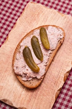 Bread with liver sausage and pickles in portrait format