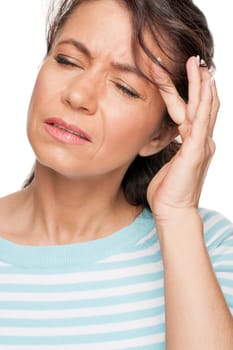 Young woman in front of white background with headache
