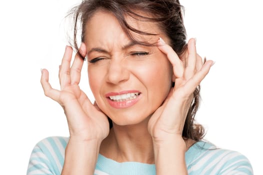 Young woman in front of white background with headache