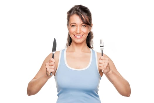 Smiling woman with cutlery against white background