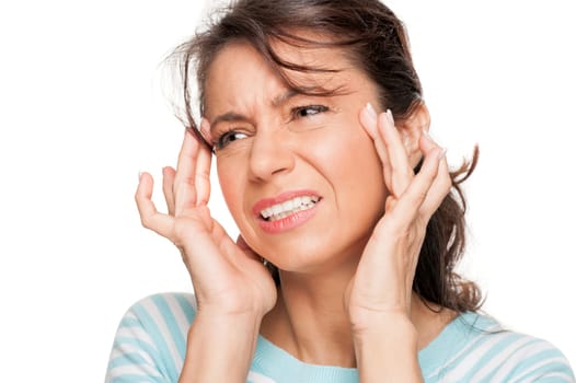 Young woman in front of white background with headache
